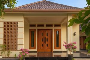 Pintu UPVC serat kayu coklat natural terpasang di rumah minimalis tropis Bekasi, tahan hujan dan rayap.